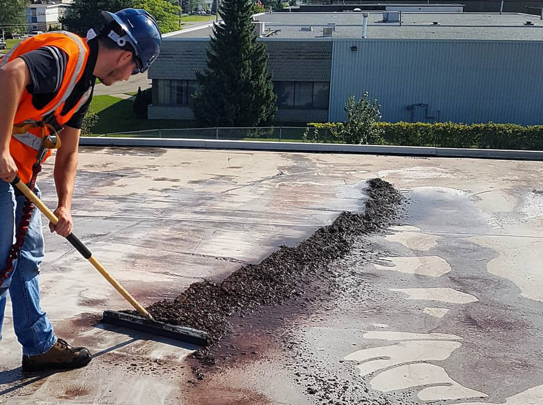 Photo of an alliance roofing employee cleaning a commercial flat roof